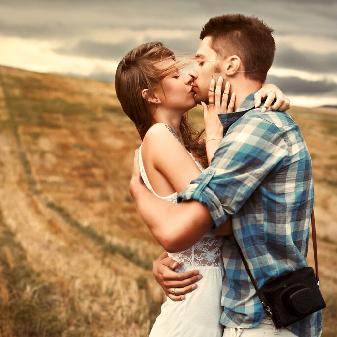 Joven pareja besándose en un campo de maíz 
