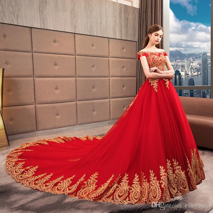 Vestido de noiva vermelho com renda dourada e cauda longa.