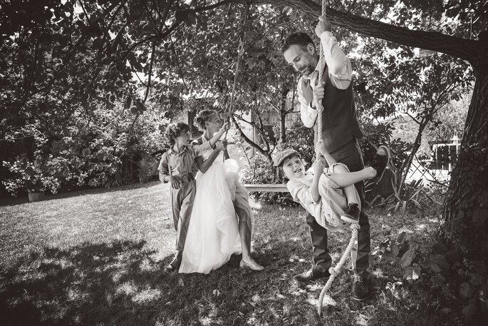 une photo des mariés avec leurs enfants sur une balançoire en noir et blanc - zOz Photographie 