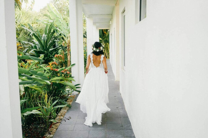 la mariée de dos court dans sa robe blanche