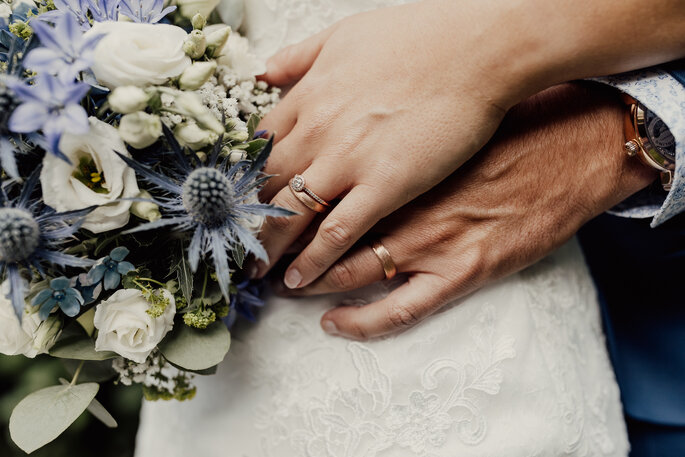 Brautpaar. Hände des Brautpaares mit Brautstrauss und Ringen