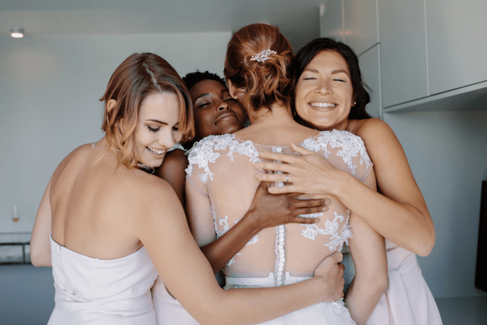Une mariée fait un câlin avec ses trois demoiselles d'honneur 