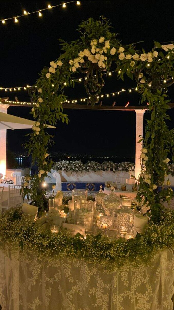 Villa Mazzarella, allestimento tavolo con cristalleria (confetti) e decorazione floreale ad arco