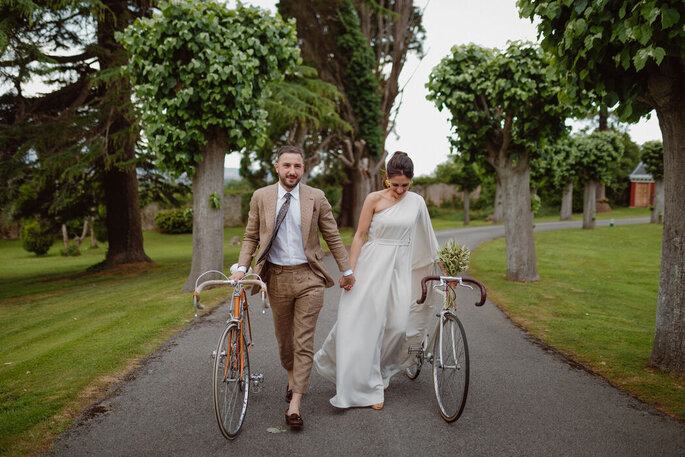 Brautpaar mit Fahrrädern laufend