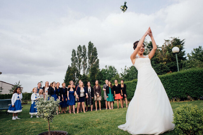 La mariée effectue le célèbre lancé de bouquet, ses invitées l'attendent avec joie