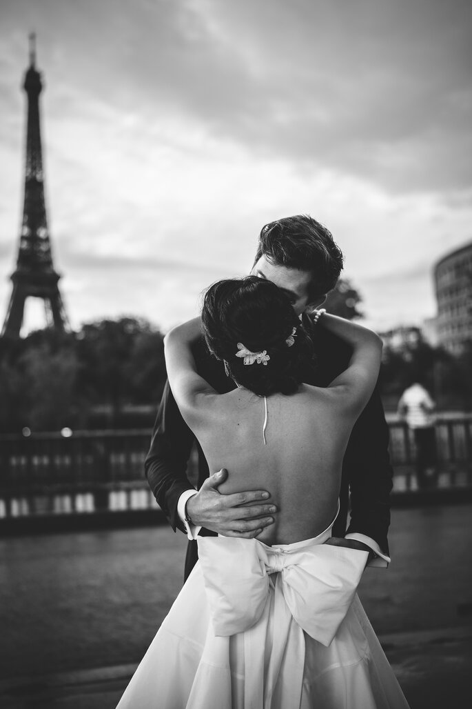 Couple de mariés posant devant la Tour Eiffel