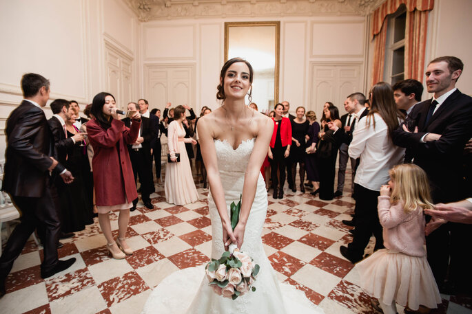 une mariée dans un sublime intérieur carrelé, prête à jeter son bouquet à ses invités au Château de Santeny