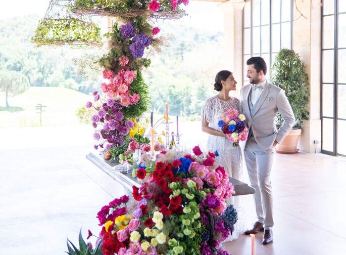 des mariés devant un chemin de table fleuri - Manakin Events 