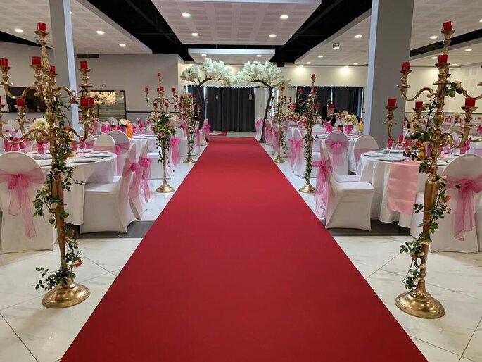 Tables dressées pour un mariage avec de superbes chandeliers de fleurs et un tapis rouge au lieu de réception Les Salons du Grand Paris dans le Val de Marne