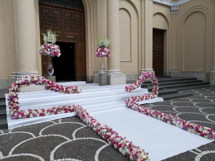 allestimento floreale bianco e rosa a pavimento e in vaso per ingresso chiesa
