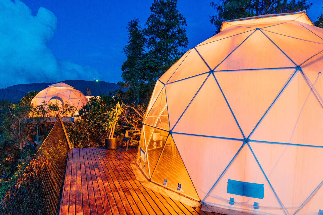 two circular glamping cabins in the middle of the forest